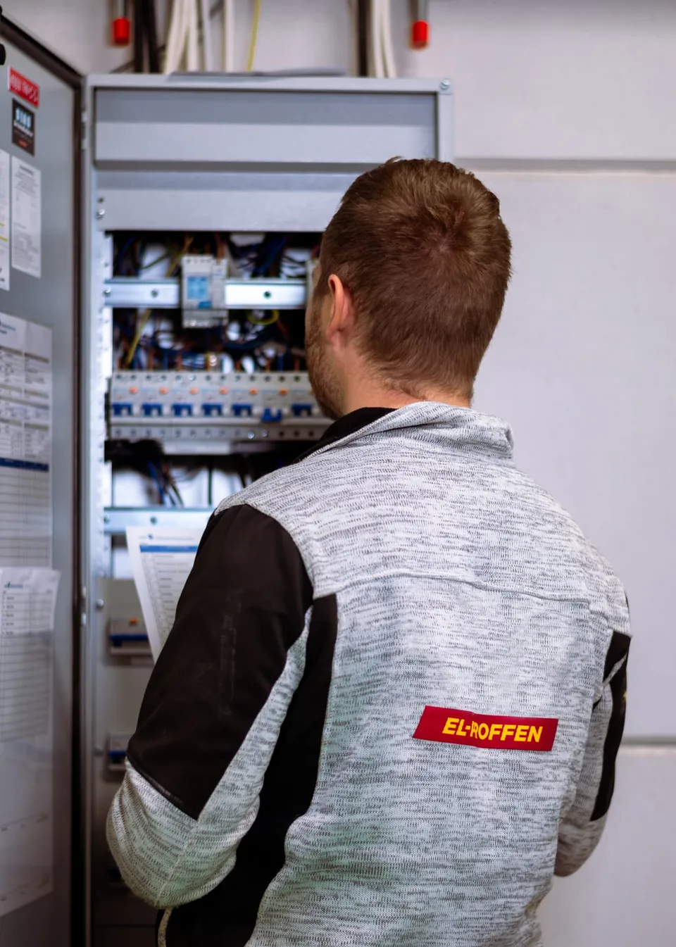 Elektriker arbeider ved et åpent sikringsskap