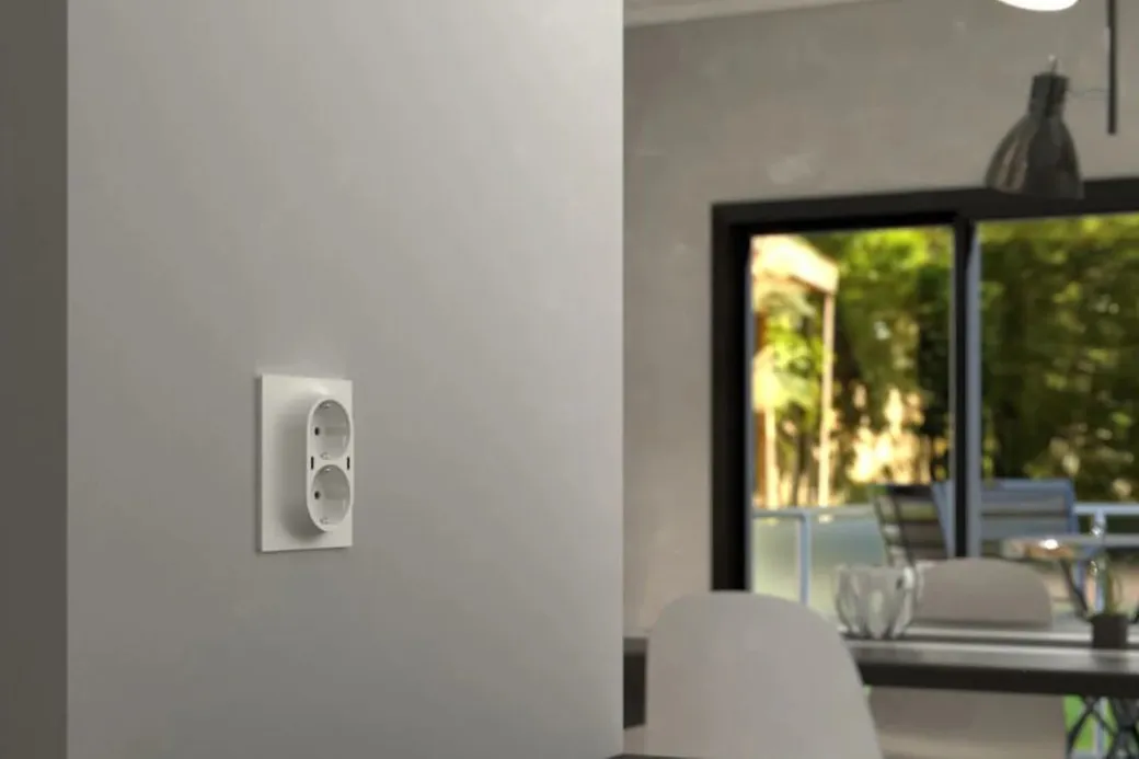 Hvit ELKO One dobbeltstikk med USB C på en stuevegg