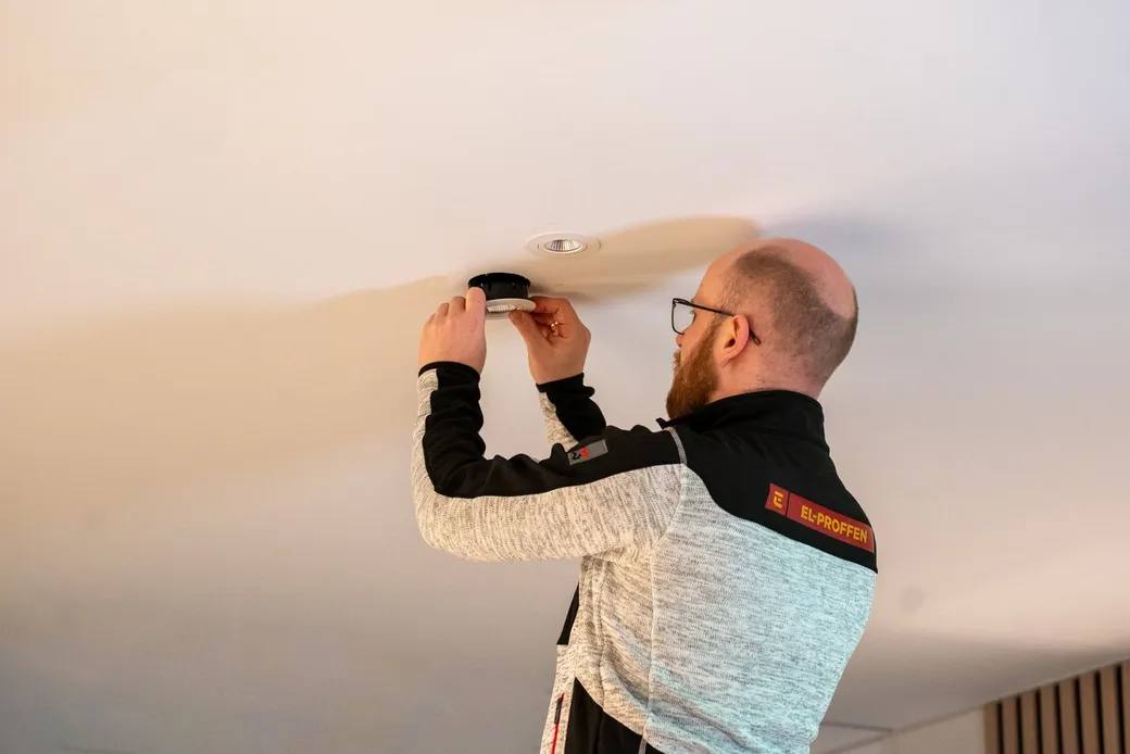 Elektriker monterer en LED downlight i taket