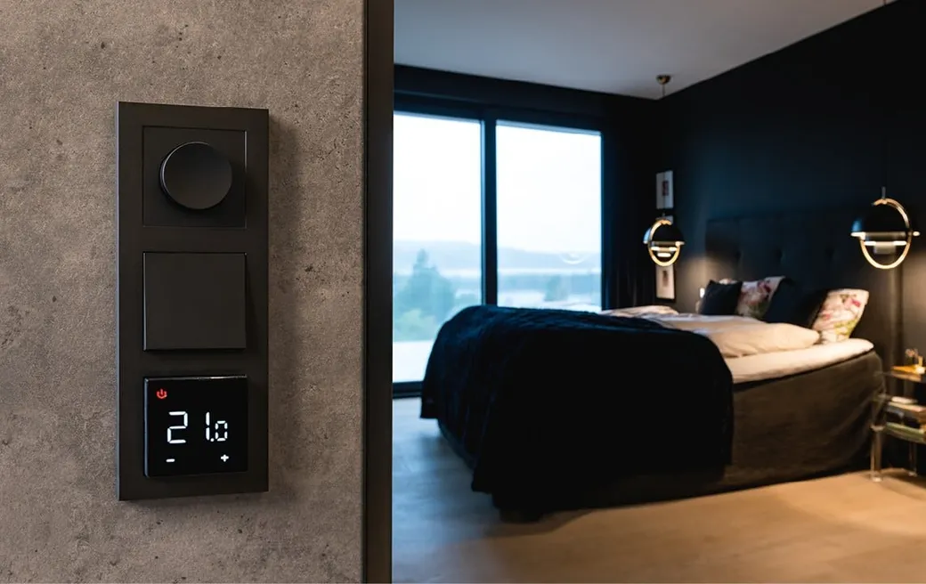 Sort SG HeatReg Smart 3.0 på en betongvegg ved et soverom