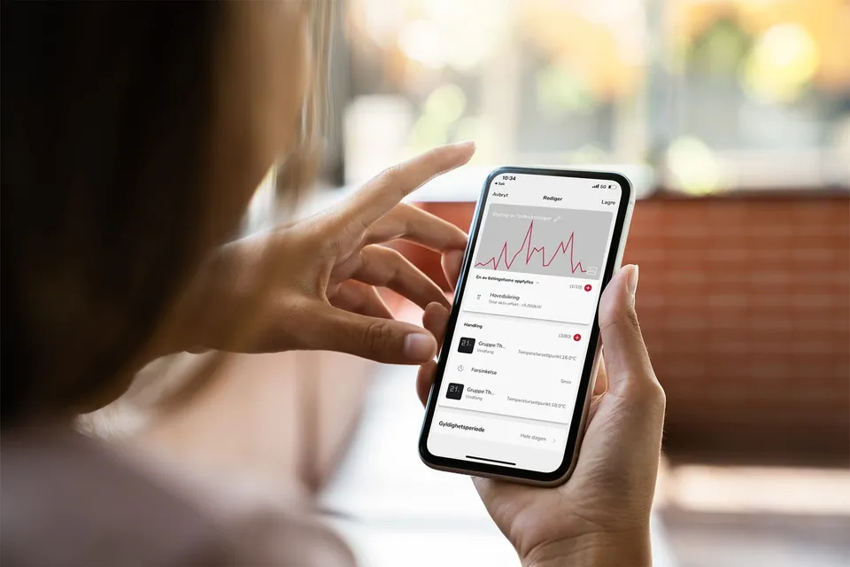Person styrer strømforbruket i en app på mobilen